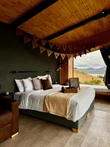 een slaapkamer met een groot bed met een groot raam bij Fuga Neusa in Tausa Viejo