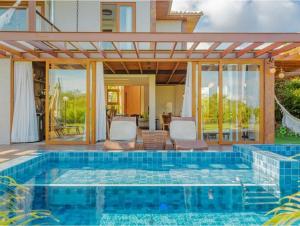 une piscine au milieu d'une maison dans l'établissement Casa PRAIA DO FORTE, à Praia do Forte 23 autres photos