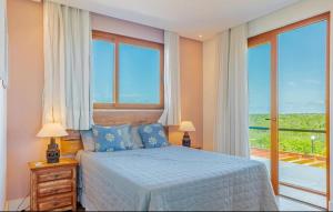 une chambre avec un lit et une grande fenêtre dans l'établissement Casa PRAIA DO FORTE, à Praia do Forte