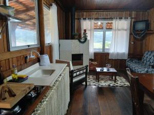 a kitchen and living room with a sink and a couch at Casas particulares Heil e Abadir in Urubici