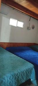 ein Schlafzimmer mit einem blauen Bett und einem Fenster in der Unterkunft El Shaddai Hospedaje Temporal in Santiago del Estero