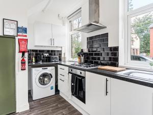 a white kitchen with a washer and dryer in it at Crew Quarters - Your Ideal Stay in Bury in Tottington