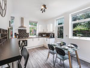 a kitchen and dining room with a table and chairs at Crew Quarters - Your Ideal Stay in Bury in Tottington