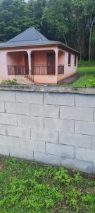 a house with a brick wall in front of it at Acomatsalon in Pointe-Noire