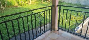 a black iron fence with a view of a yard at Acomatsalon in Pointe-Noire