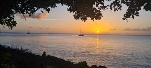 a sunset over the ocean with boats in the water at Acomatsalon in Pointe-Noire