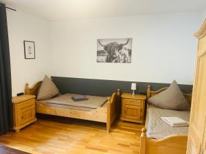 a room with two beds and a bull on the wall at Landhaus Magnus in Ramberg