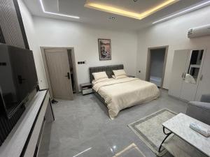 a bedroom with a bed and a tv and a couch at قمرة قباء Quba moon3 in Al Madinah