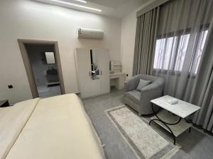 a hotel room with a bed and a chair at قمرة قباء Quba moon3 in Al Madinah