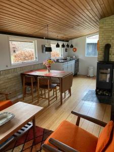 Il comprend une cuisine et un salon avec une table et une cuisinière. dans l'établissement Nostalgic 1960S Idyll, à Hornsved