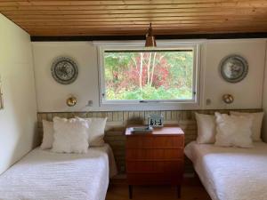 deux lits dans une chambre avec une fenêtre dans l'établissement Nostalgic 1960S Idyll, à Hornsved