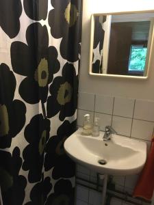 La salle de bains est pourvue d'un lavabo et d'un rideau de douche noir et blanc. dans l'établissement Nostalgic 1960S Idyll, à Hornsved