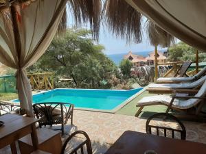 a patio with chairs and a swimming pool at Villa Naylamp Loft 2 familiar playa pocitas in Máncora