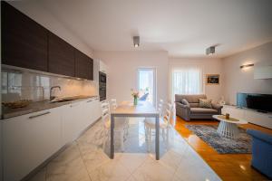 eine Küche und ein Wohnzimmer mit einem Tisch und einer Couch in der Unterkunft Apartments DYANA in Novalja