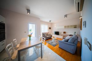 ein Wohnzimmer mit einem Tisch und ein Esszimmer in der Unterkunft Apartments DYANA in Novalja