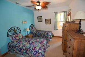 a bedroom with a bed and a chair and a ceiling fan at 3-bedroom Poolside San Felipe Vacation villa in La Ponderosa