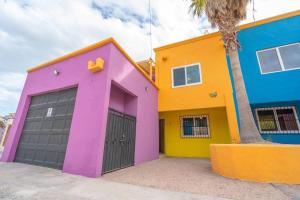 a colorful house with two garage doors and a palm tree at Condo 5, in San Felipe Just Steps to the Beach, Near the Malecon. in San Felipe