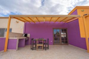 a purple and yellow house with a table and chairs at Condo 5, in San Felipe Just Steps to the Beach, Near the Malecon. in San Felipe