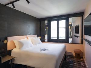 a bedroom with a large white bed and a window at TRIBE Paris Batignolles in Paris