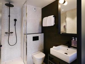 a bathroom with a shower and a toilet and a sink at TRIBE Paris Batignolles in Paris +90 photos