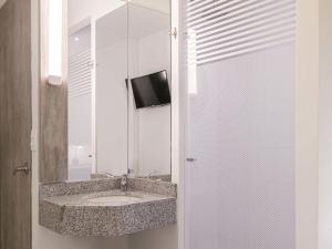 a bathroom with a sink and a mirror at ibis budget Barranquilla in Barranquilla