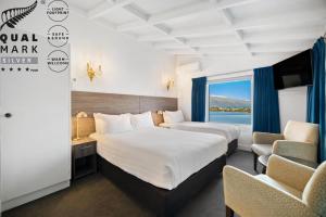 クイーンズタウンにあるLakeview Colonial Motelのベッドが2つと窓があるホテルの部屋