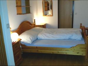 a bedroom with a wooden bed with a blue mattress at Gibelhüüs 2 Bettwohnung in Hasliberg Wasserwendi
