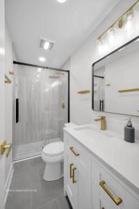 a white bathroom with a shower and a toilet at Chicago Gem! Centrally Located - proximity to O' Hare Airport in Schaumburg
