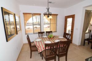 a dining room with a table and chairs and windows at El Dorado Ranch Vacation Rental Condo 25-1 | 18-Hole Golf in Playa El Paraíso