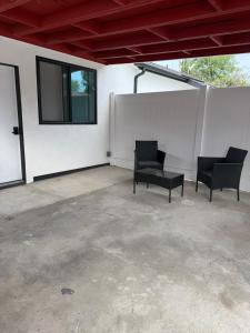 a patio with two black chairs and a window at Guesthouse in Hewitt