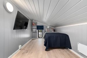 Un dormitorio con una cama y un televisor de pantalla plana. en Norefri - Norefjell, en Ørpen