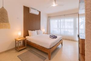 a bedroom with a bed and a large window at Hotel Santa Teresa by the Beach in Santa Teresa Beach