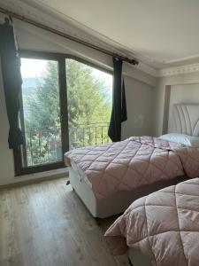 a bedroom with two beds and a large window at House overlooking a lake 