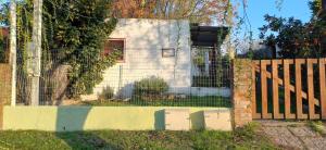 ein Zaun vor einem Haus mit einem Tor in der Unterkunft Puka ra in Colonia del Sacramento