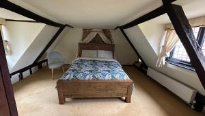 GeldestonにあるDanegelts Waveney Marshes Bed & Breakfastの屋根裏にキャノピーベッドが備わるベッドルーム1室が備わります。