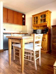 a kitchen with a wooden table and chairs at Ski&Sky Studiò 85 in Pila