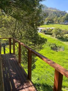 a wooden deck with a view of a field at Casa del Árbol Sesquile in Tres Esquinas