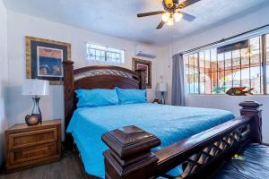 a bedroom with a bed with a blue comforter and a window at Huge Family 5 bedroom sleeps 16 with private pool home in San Felipe