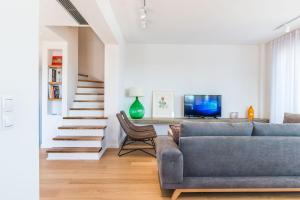 een woonkamer met een blauwe bank en een tafel bij Happy Villa in Galatás