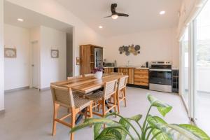 a kitchen with a wooden table and chairs at Hotel Santa Teresa by the Beach in Santa Teresa Beach
