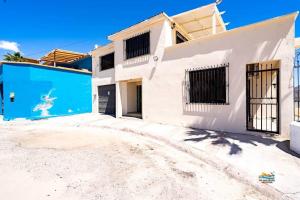 a white house with a blue garage at InTown Beach front condo - Casey`s condo 1 in San Felipe