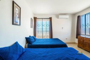 a bedroom with two blue beds and a window at InTown Beach front condo - Casey`s condo 1 in San Felipe +27 photos