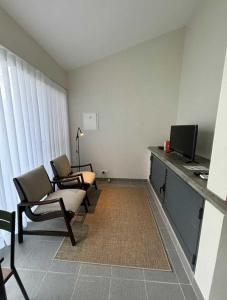 a living room with two chairs and a television at Casa da Mónica in Ponta Delgada