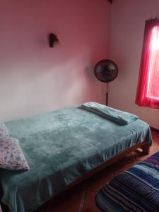 a bedroom with a bed with a green blanket at Casa Los colibrí in Frente Mar
