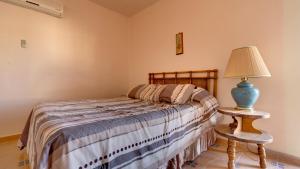 a bedroom with a bed and a lamp on a table at El Dorado Ranch San Felipe Rental - Judy`s Casita in Playa El Paraíso