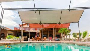 a swimming pool with an umbrella over a house at Paradise home in Rancho Percebu in San Felipe