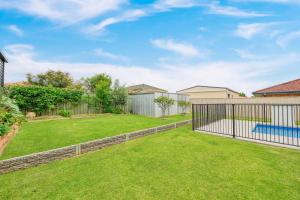 a yard with a fence and a pool at The Drift at Cathie in Lake Cathie
