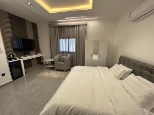 a hotel room with a large bed and a chair at قمرة قباء Quba moon5 in Al Madinah