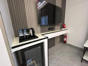a room with a television and a counter with water bottles at قمرة قباء Quba moon5 in Al Madinah