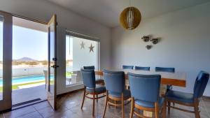 a dining room with a table and blue chairs at Amazing El Dorado Ranch Pool house La Kasa 53 in Playa El Paraíso +27 photos